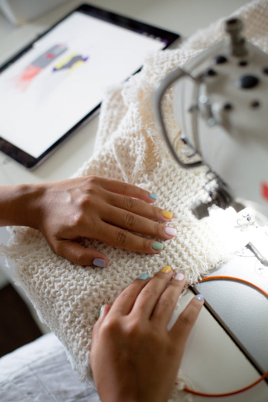 hands-line-up-fabric-into-a-sewing-machine