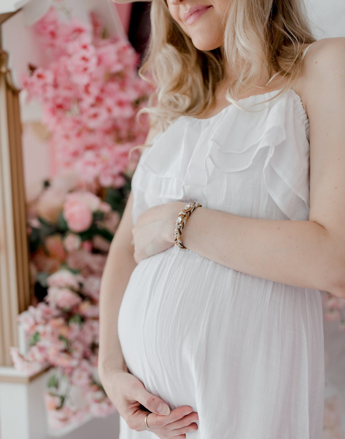 pregnant-woman-in-a-white-dress-holds-her-belly